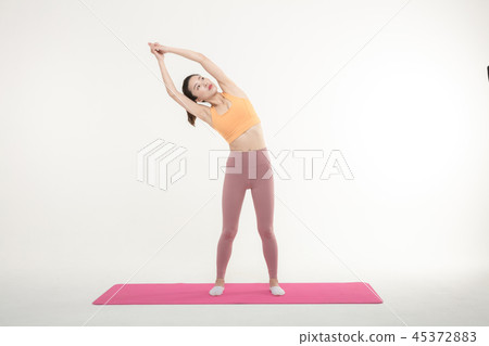 A Korean woman doing yoga exercise on mat A Korean woman doing yoga exercise on mat 45372883