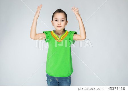 The girl on the grey background hands in the air. 45375438