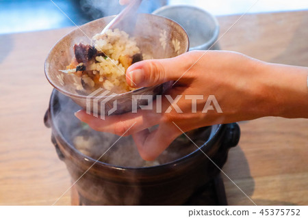 Put hot rice in a bowl 45375752