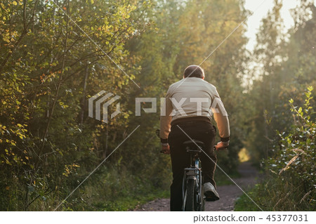 Portrait of man riding cycle in countryside Portrait of man riding cycle in countryside 45377031