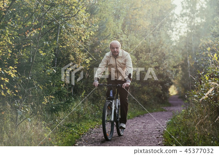 Portrait of man riding cycle in countryside. Portrait of man riding cycle in countryside. 45377032