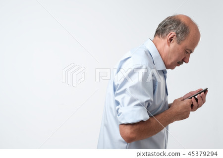 Mature man reading sms on phone. Mature man reading sms on phone. 45379294