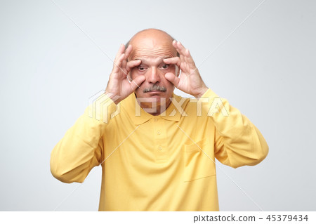 senior man trying to open his eyes with fingers. 45379434