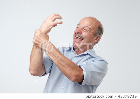 Mature man trying to control his hand. 45379739