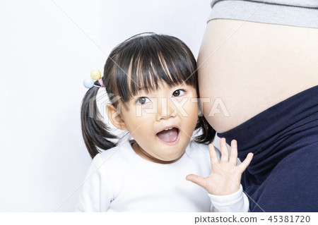 A little girl who listens to the movement of the pregnant mother by listening to the large belly of the pregnant mother last month. Pregnancy, pregnant woman, family, love, happiness image A little girl who listens to the movement of the pregnant mother by listening to the large belly of the pregnant mother last month. Pregnancy, pregnant woman, family, love, happiness image 45381720