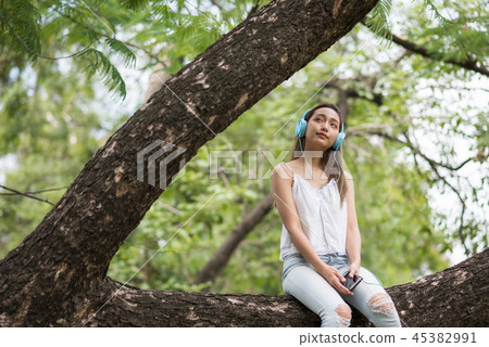 girl listen to streaming music in park girl listen to streaming music in park 45382991