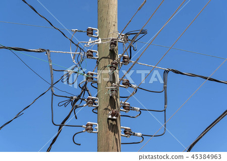 Electric cables tangle on wood post 45384963