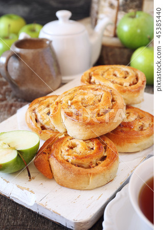 Apple-cinnamon sweet buns, green apples and tea Apple-cinnamon sweet buns, green apples and tea 45385440