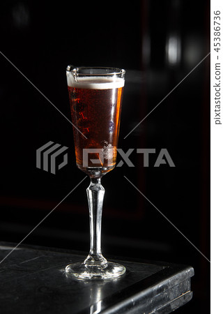 kir royal on a bar desk. black background. 45386736