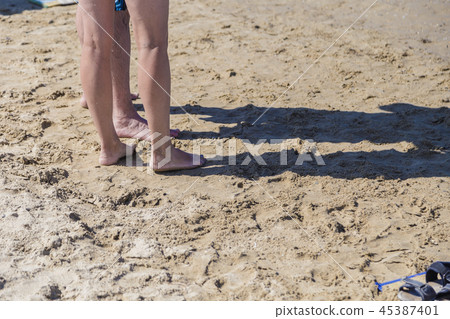 Legs on the sea sand near the sea shore on a 45387401