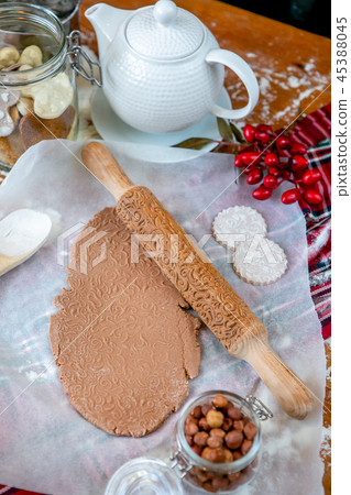 Rolling pin with a pattern on a wooden decorated table covered with baked flour. Rolled dough with a Rolling pin with a pattern on a wooden decorated table covered with baked flour. Rolled dough with a 45388045