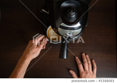 Photo of coffee maker, hands of man pouring coffee in mug 45388083