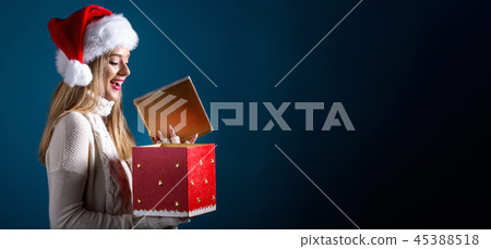 Young woman opening a Christmas gift box 45388518