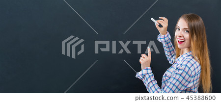 Young woman writing on a chalkboard Young woman writing on a chalkboard 45388600