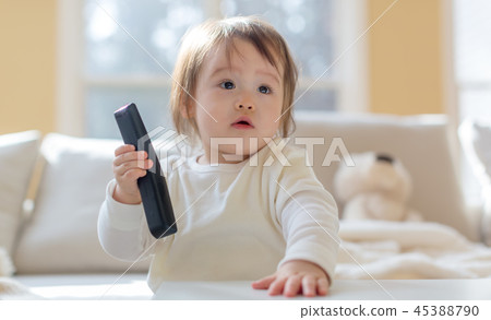 Toddler boy with a TV remote control Toddler boy with a TV remote control 45388790