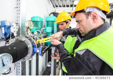 Two workers fixing pipes 45389271