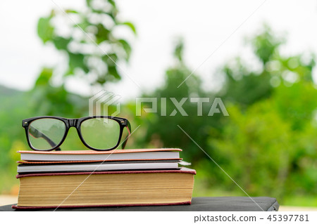 Books and eyeglasses with nature background. Books and eyeglasses with nature background. 45397781