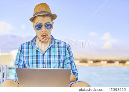 A man is working on vacation. 45398633
