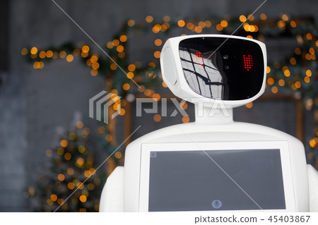 Humanoid autonomous robot on the background of Christmas decorations, Christmas tree, bokeh 45403867