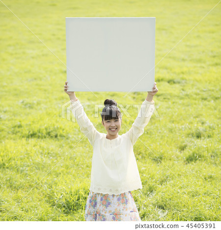 舉行whiteboard的婦女在草甸 45405391