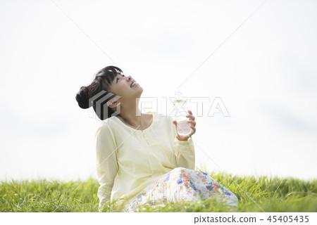 女人保濕在草地上 女人保濕在草地上 45405435