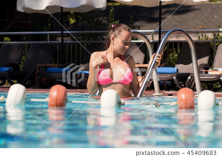 Wet woman leaving swimming pool 45409683