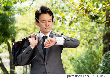 A businessman looking at a watch 45410423