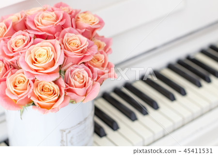 Beautiful pink roses in a round box on the piano. 45411531