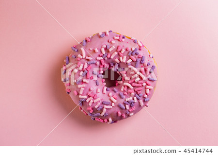 Single round donut on pink background. 45414744