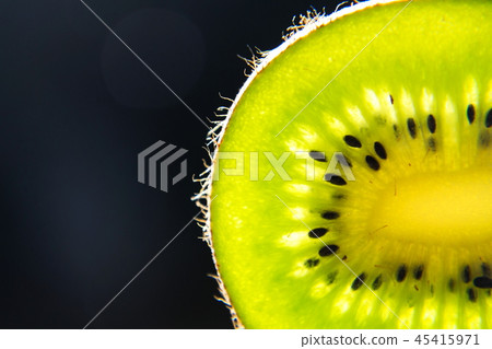 Green fresh kiwi fruit sliced piece stands backlit 45415971
