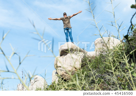 man with his arms in the air on the top of a rock man with his arms in the air on the top of a rock 45416500