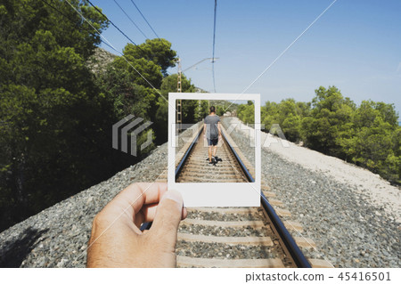 young man walking by the railroad tracks young man walking by the railroad tracks 45416501