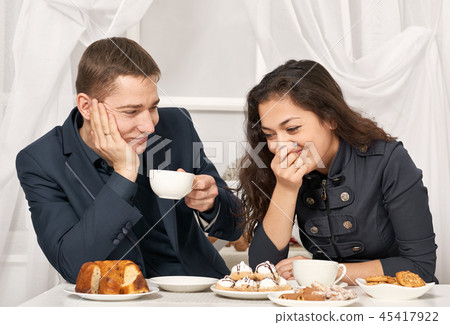 romantic couple drinking tea with cookies, talking 45417922