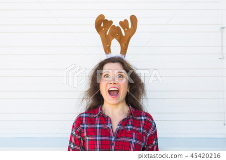 Portrait of laughing woman with Christmas deer horns on white background Portrait of laughing woman with Christmas deer horns on white background 45420216