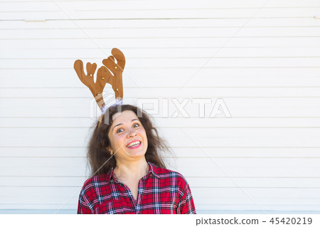 Portrait of cheerful woman with Christmas deer horns on white background with copy space Portrait of cheerful woman with Christmas deer horns on white background with copy space 45420219