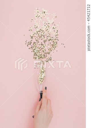 Champagne glass poured out golden stars confetti 45421712