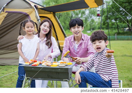 Family having picnic outdoors. Parents with two children relax in the park. Concept of happy family relations and carefree leisure time. 278 45428497