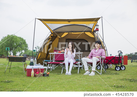 Family having picnic outdoors. Parents with two children relax in the park. Concept of happy family relations and carefree leisure time. 216 Family having picnic outdoors. Parents with two children relax in the park. Concept of happy family relations and carefree leisure time. 216 45428570
