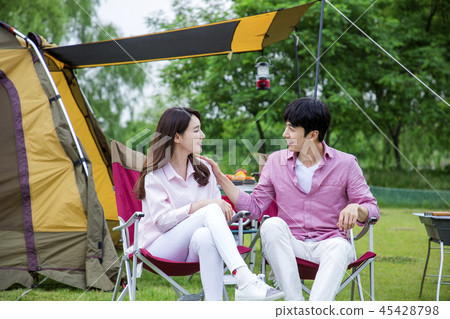 Family having picnic outdoors. Parents with two children relax in the park. Concept of happy family relations and carefree leisure time. 266 Family having picnic outdoors. Parents with two children relax in the park. Concept of happy family relations and carefree leisure time. 266 45428798