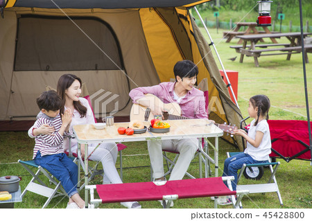 Family having picnic outdoors. Parents with two children relax in the park. Concept of happy family relations and carefree leisure time. 208 45428800