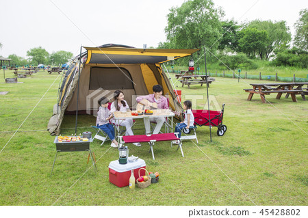 Family having picnic outdoors. Parents with two children relax in the park. Concept of happy family relations and carefree leisure time. 207 Family having picnic outdoors. Parents with two children relax in the park. Concept of happy family relations and carefree leisure time. 207 45428802