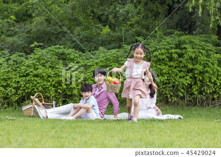 Family having picnic outdoors. Parents with two children relax in the park. Concept of happy family relations and carefree leisure time. 094 Family having picnic outdoors. Parents with two children relax in the park. Concept of happy family relations and carefree leisure time. 094 45429024