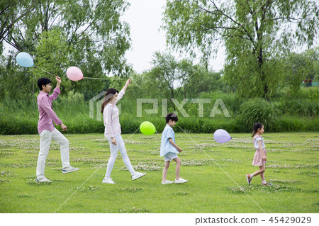 Family having picnic outdoors. Parents with two children relax in the park. Concept of happy family relations and carefree leisure time. 002 Family having picnic outdoors. Parents with two children relax in the park. Concept of happy family relations and carefree leisure time. 002 45429029