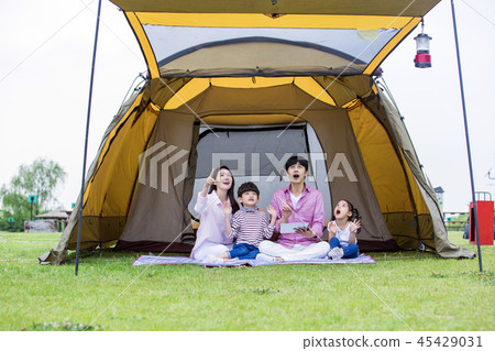 Family having picnic outdoors. Parents with two children relax in the park. Concept of happy family relations and carefree leisure time. 186 Family having picnic outdoors. Parents with two children relax in the park. Concept of happy family relations and carefree leisure time. 186 45429031