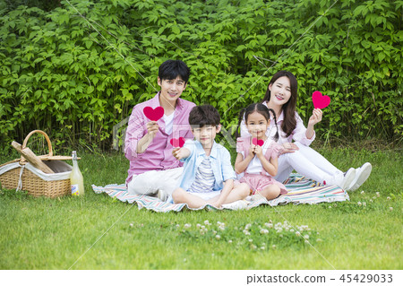 Family having picnic outdoors. Parents with two children relax in the park. Concept of happy family relations and carefree leisure time. 091 Family having picnic outdoors. Parents with two children relax in the park. Concept of happy family relations and carefree leisure time. 091 45429033