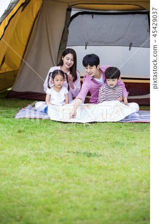 Family having picnic outdoors. Parents with two children relax in the park. Concept of happy family relations and carefree leisure time. 178 Family having picnic outdoors. Parents with two children relax in the park. Concept of happy family relations and carefree leisure time. 178 45429037