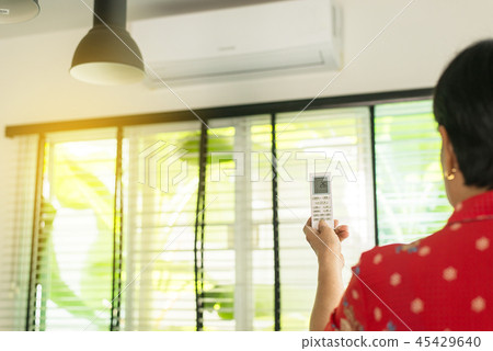 Hands using a remote control to activating air 45429640