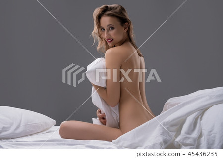 Nude girl sitting on her bed rearview 45436235