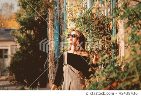Young girl in dress and black clothes near house 45439436