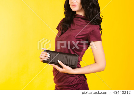 Stylish girl in a burgundy dress holding a purse Stylish girl in a burgundy dress holding a purse 45440212